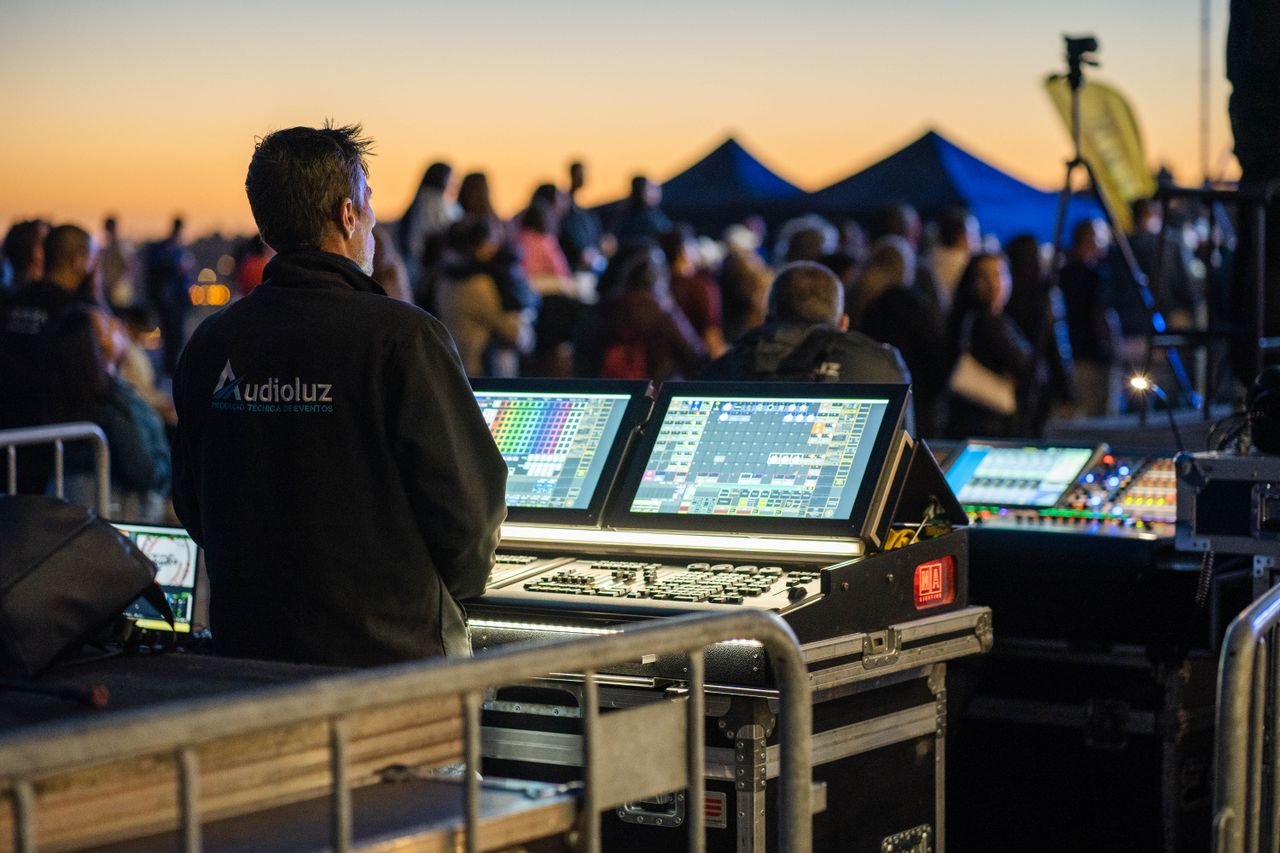Mastering the First Impression: Your intriguing post title goes here Technician managing sound and lighting panels during an outdoor event at sunset.